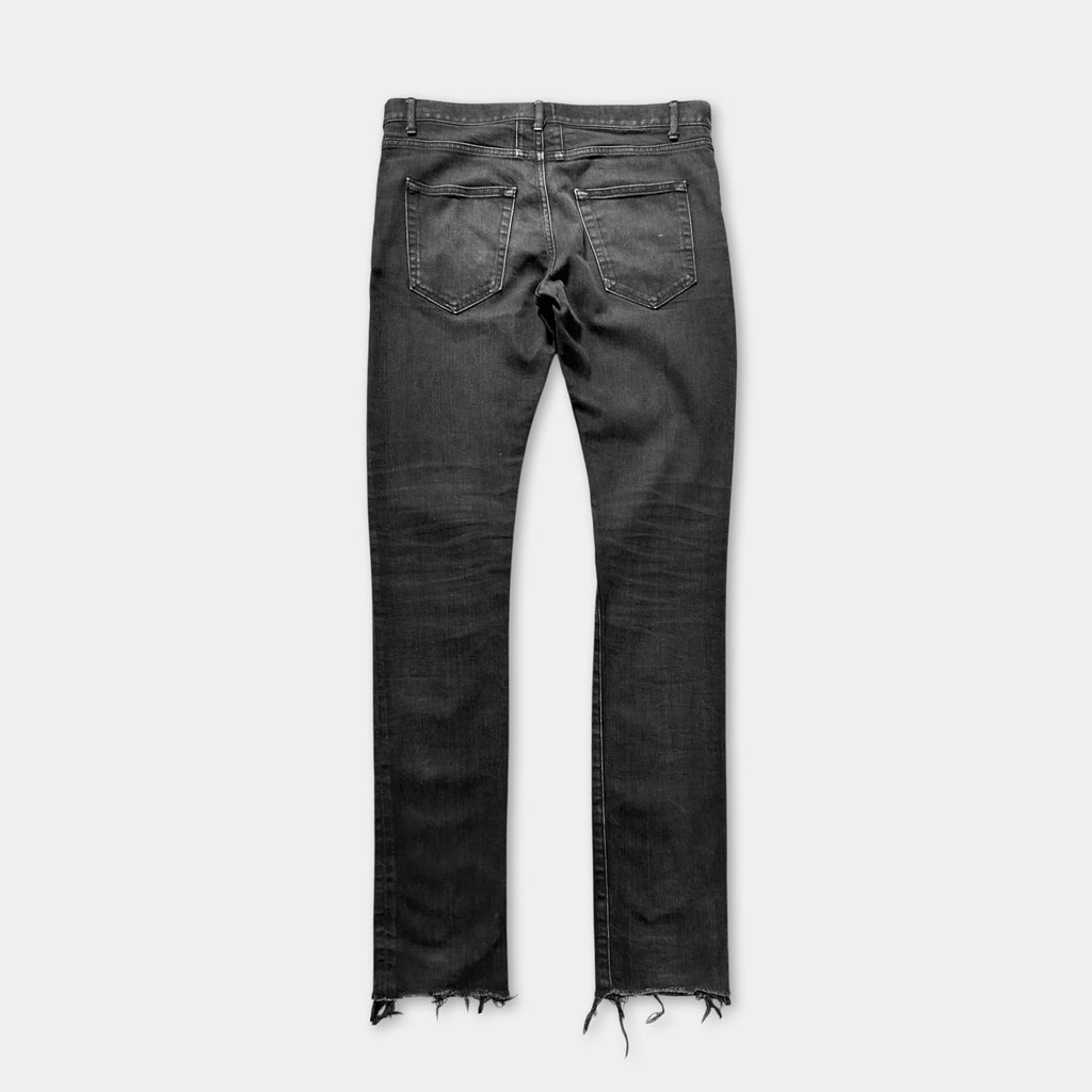 A pair of black jeans with frayed edges and a zipper closure.