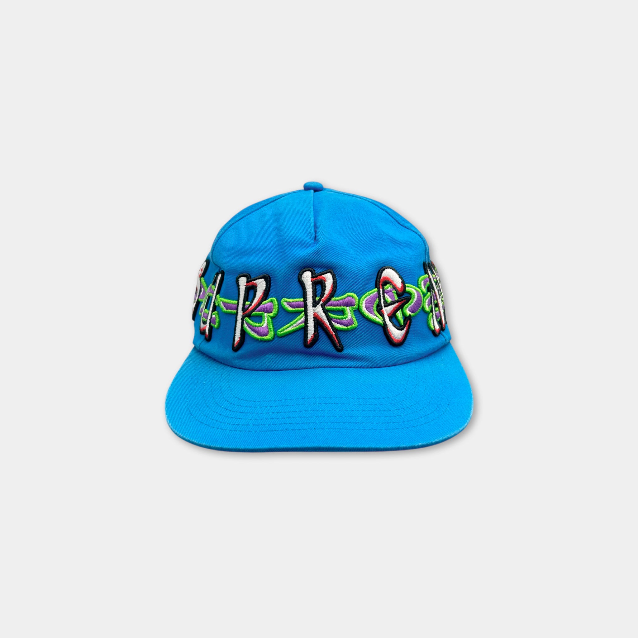 A blue baseball cap with colorful embroidered text on it.
