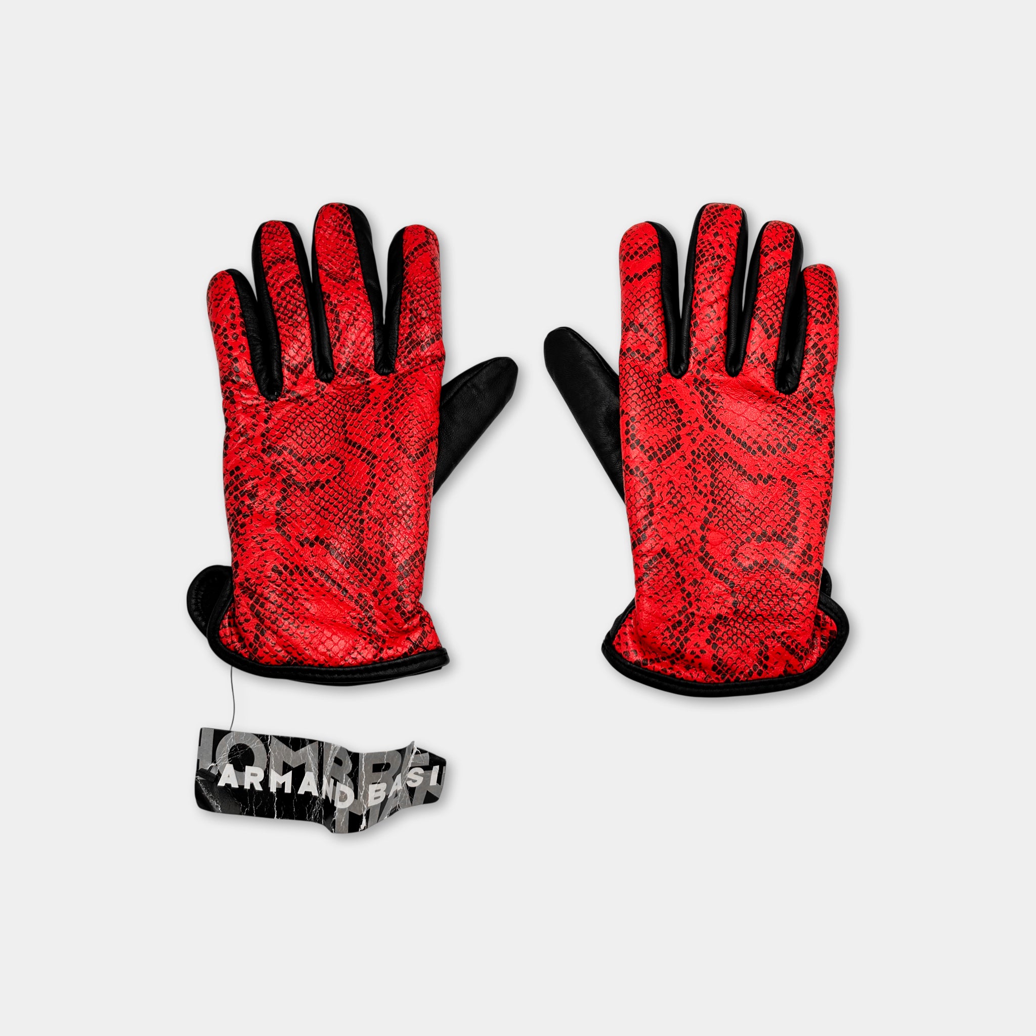 A pair of red and black gloves with a snake skin pattern, placed on a white background.