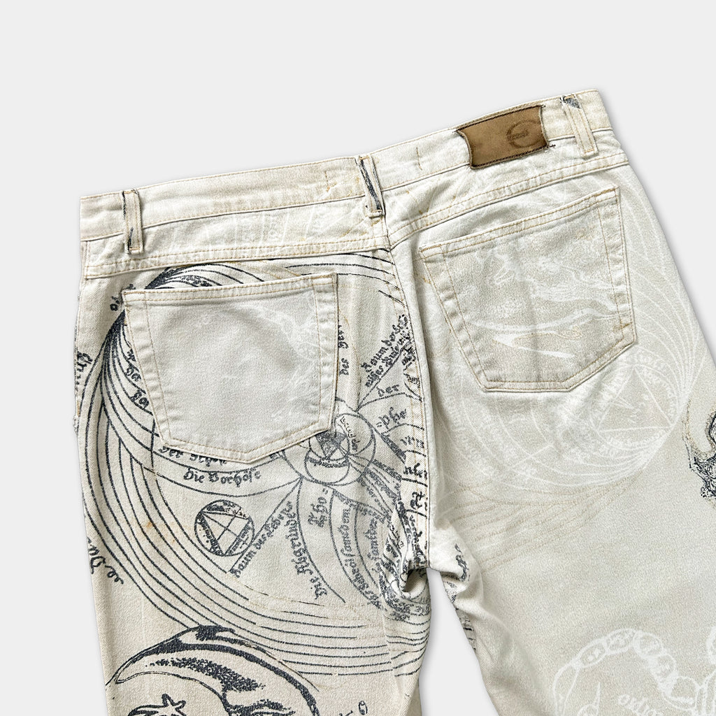 a pair of beige jeans with a unique printed design on the back pocket and the lower part of the jeans.
