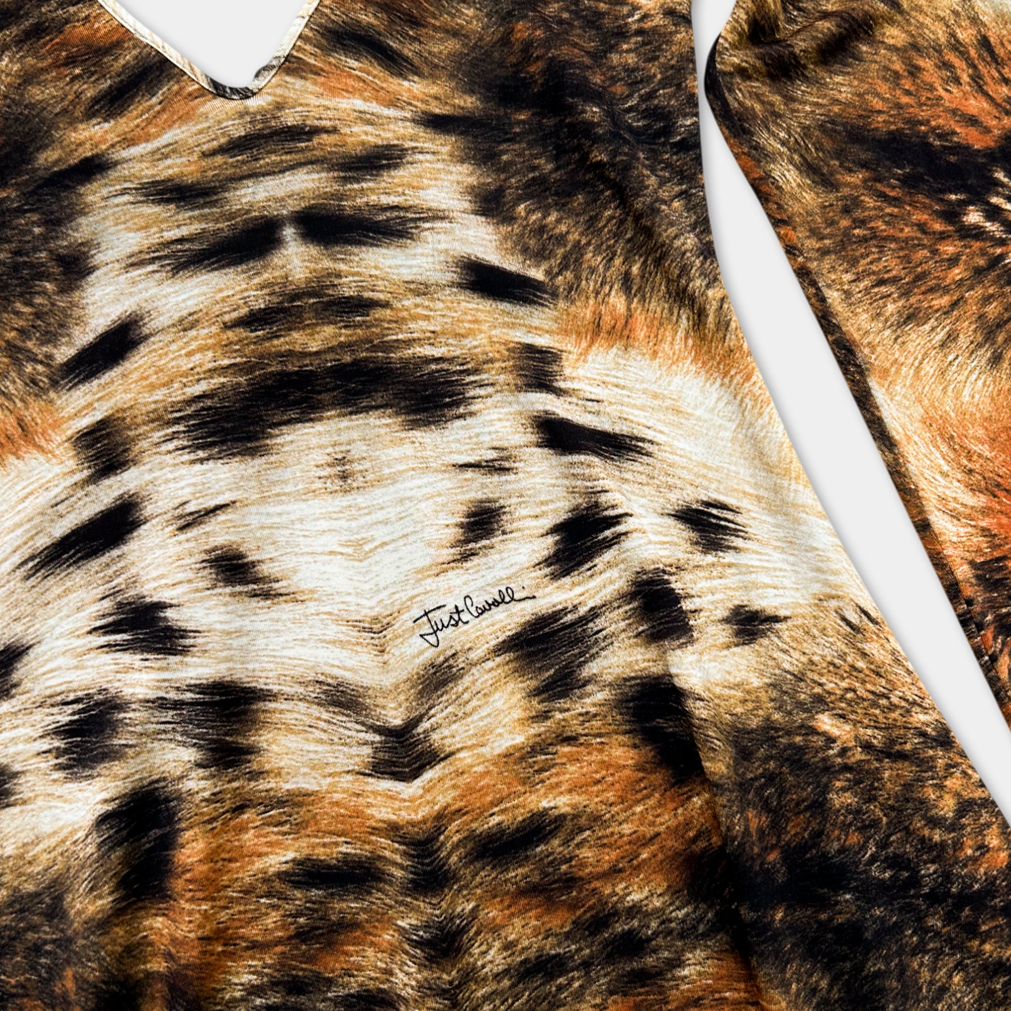 a close-up view of a fabric with a striking tiger-like pattern, including shades of brown, black, and orange.