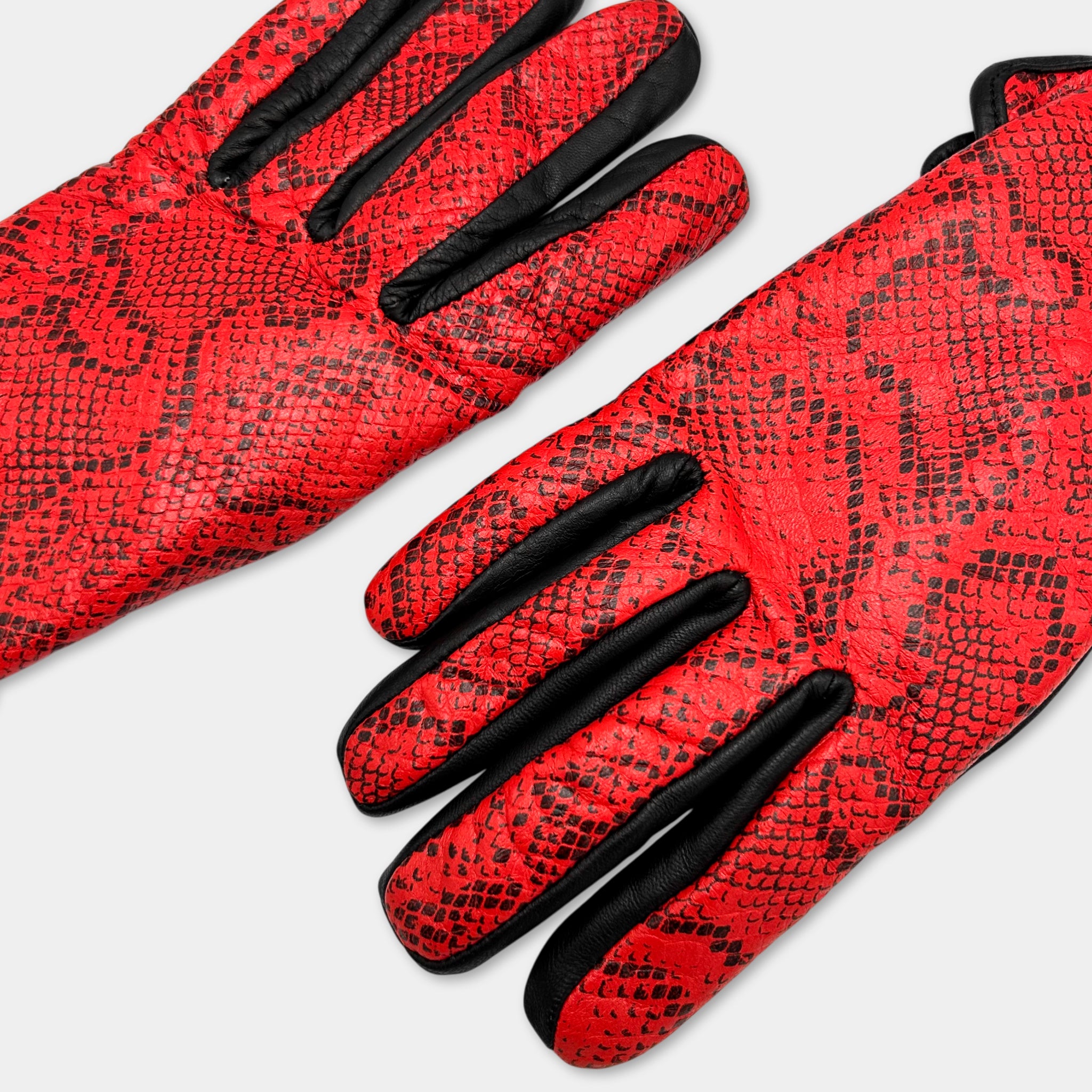 A pair of red and black patterned gloves with a distinctive snake skin texture.
