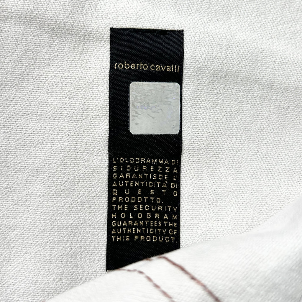 a close-up of a black label with text on it, placed on a white fabric background.