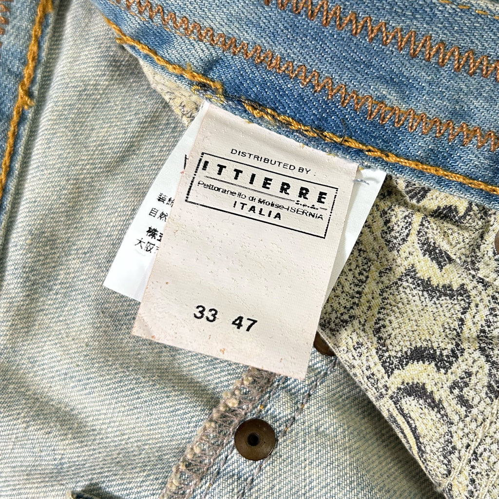 a close-up view of a denim fabric, with a label attached to it. The label is from a brand called "ITTIERE" and displays the number "33 47".