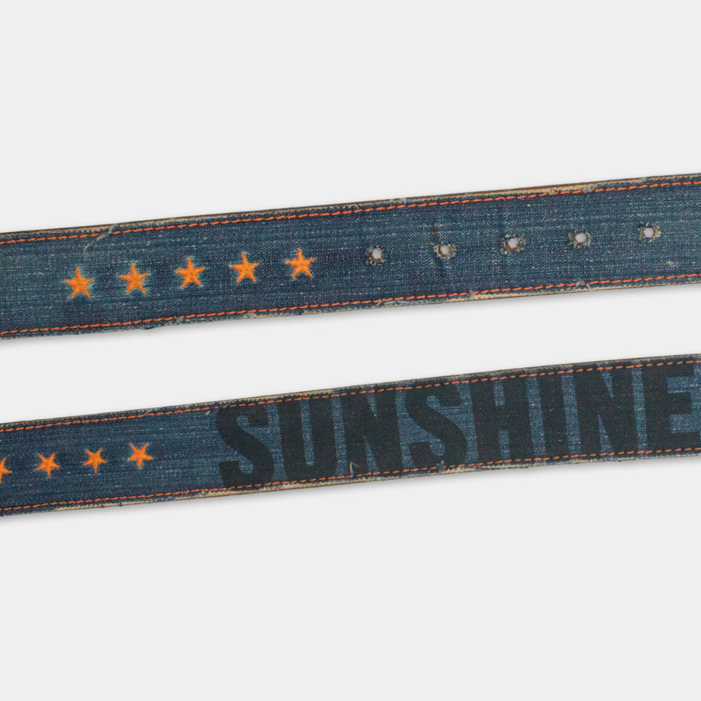 a pair of blue denim belts with orange stars and the word "SUNSHINE" printed on them.