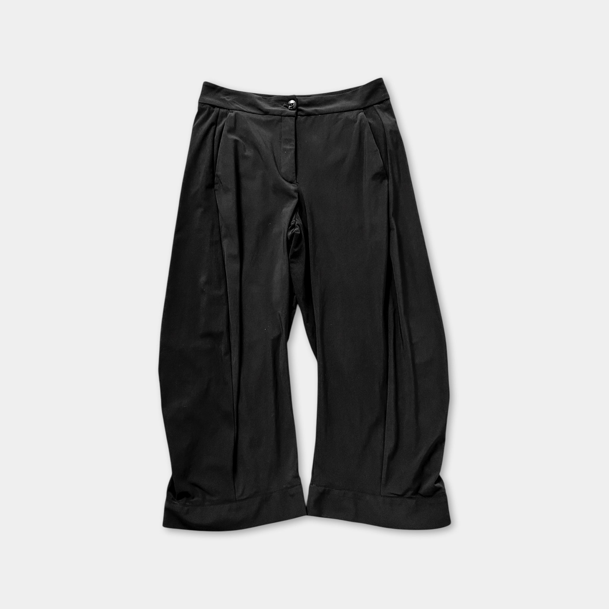 A pair of black pants with a button waistband and a flared leg.