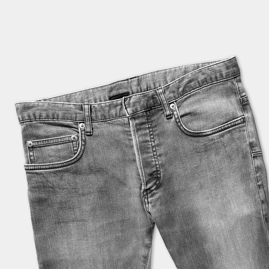 A pair of gray jeans with a pocket on the front.