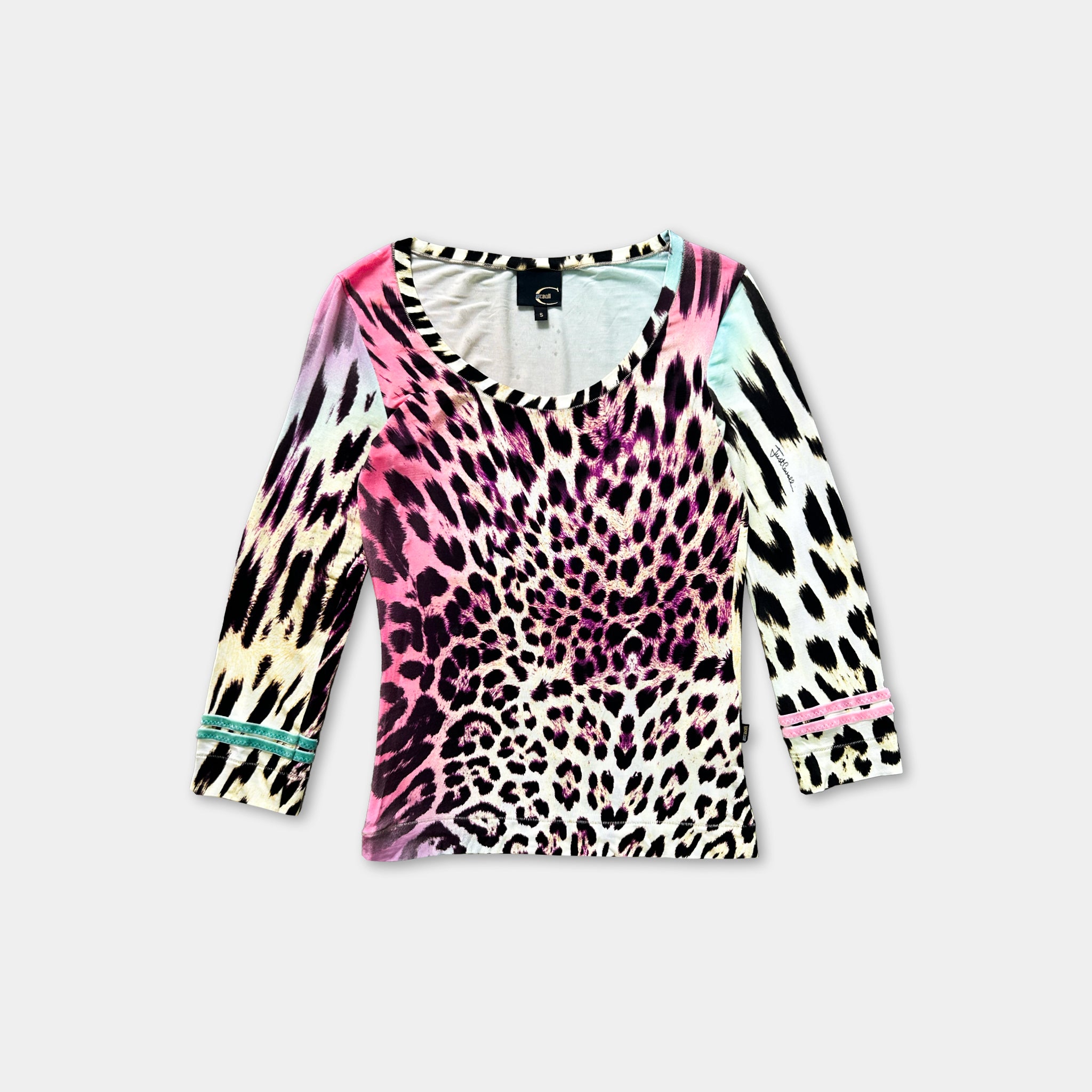 A colorful leopard print top with a vibrant pattern of pink, black, and white spots.