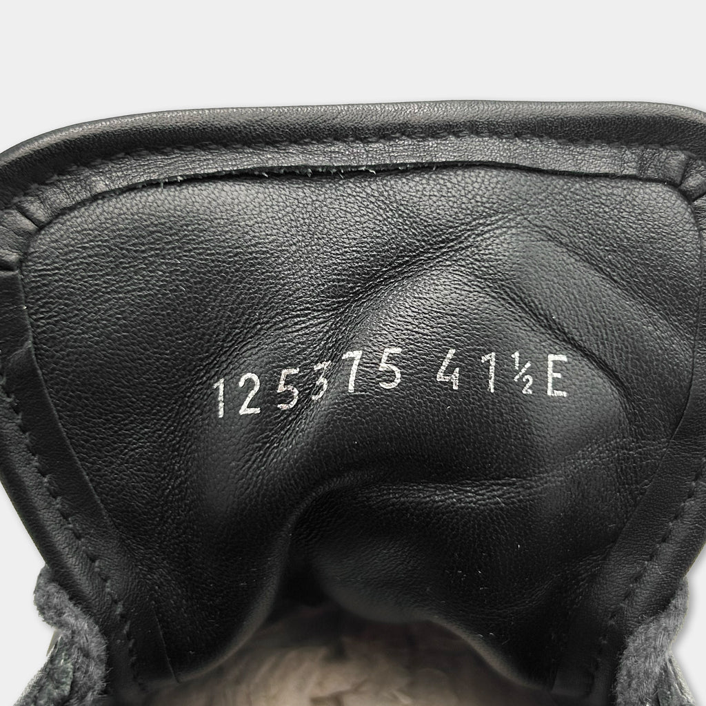 the inside of a black shoe, specifically the sole and the heel. There is a series of numbers printed on the sole, which appear to be a serial number or a model identification number.