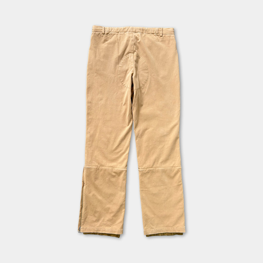 A pair of khaki-colored pants with a zipper detail on the side.