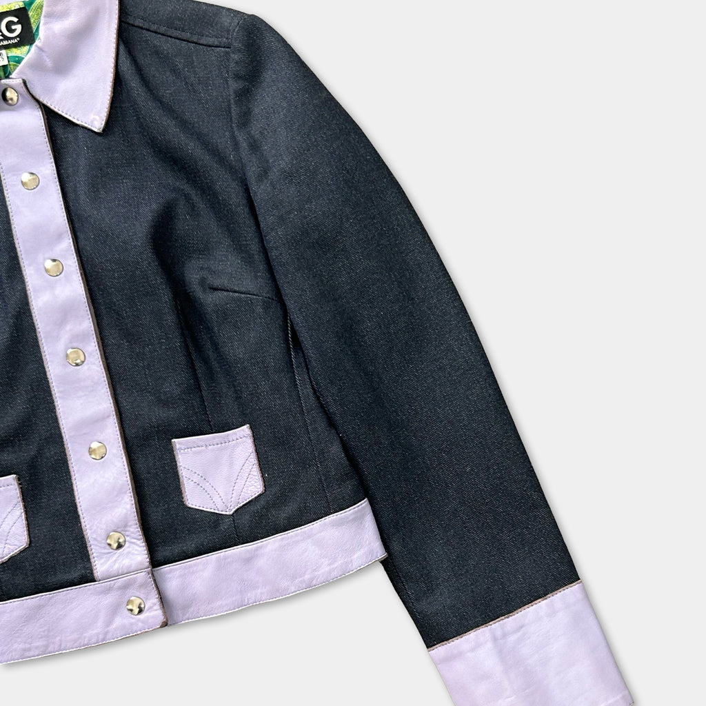 A black and white jacket with a purple collar and buttons, displayed on a white background.