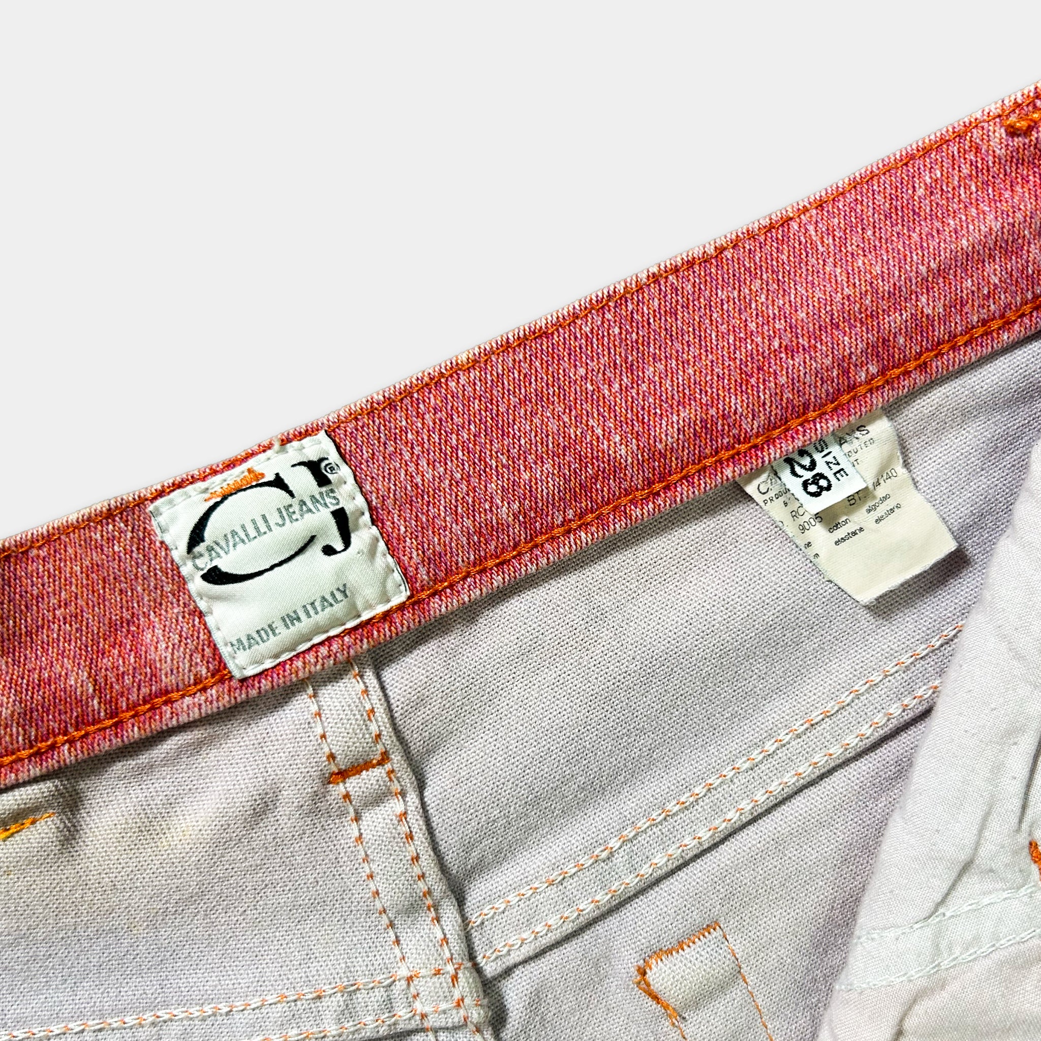 a close-up view of a red and white belt with a label on it, indicating the brand and material of the jeans.