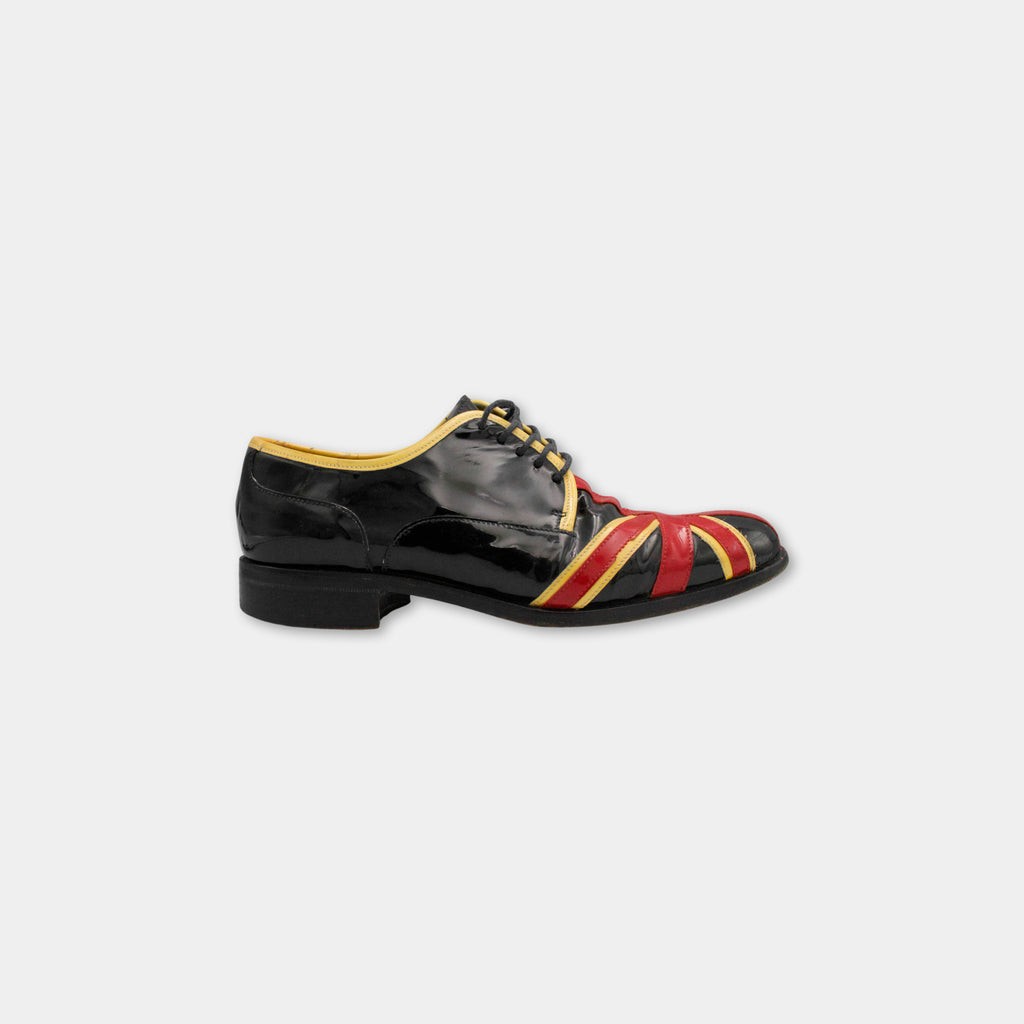 A black and red shoe with a distinctive red and yellow pattern on the side.