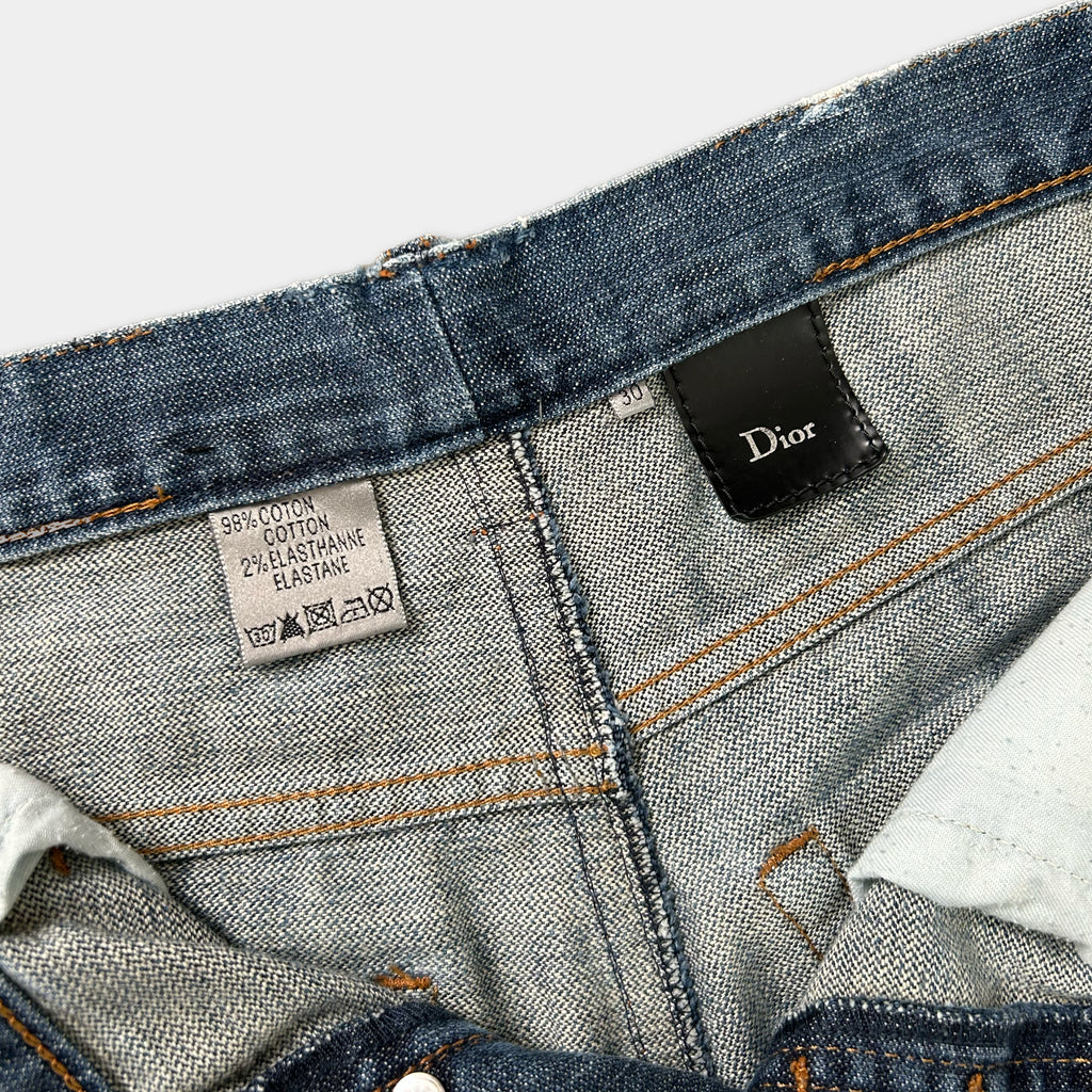 a close-up view of a pair of blue denim jeans, with a label attached to the waistband.