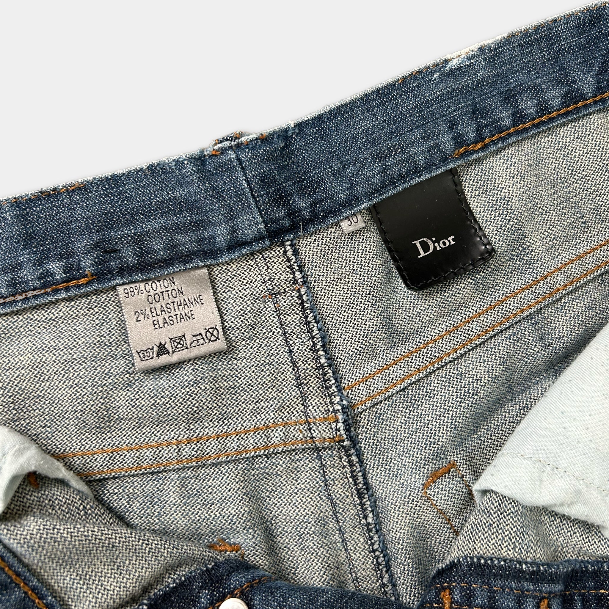 a close-up view of a pair of blue denim jeans, with a label attached to the waistband.