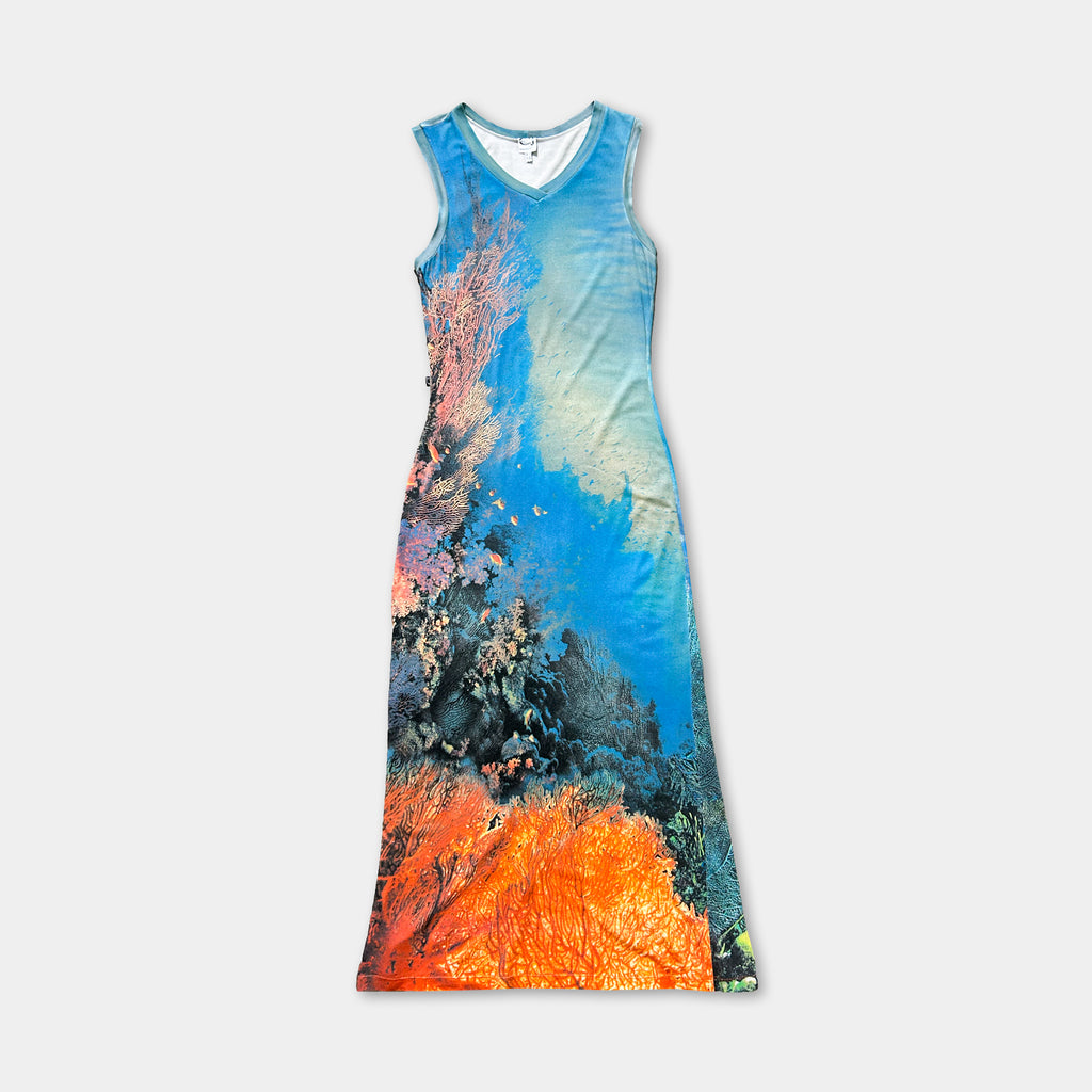A colorful dress with a printed design depicting a tropical or ocean scene, featuring a mix of blue, orange, and green colors.