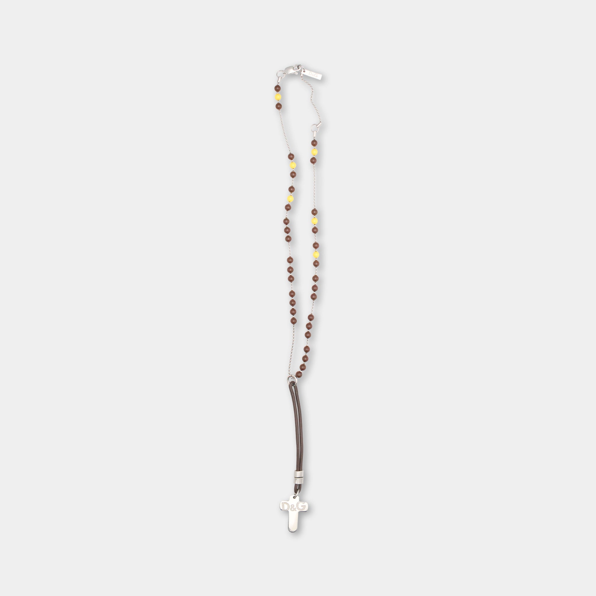 A silver cross necklace with brown beads.
