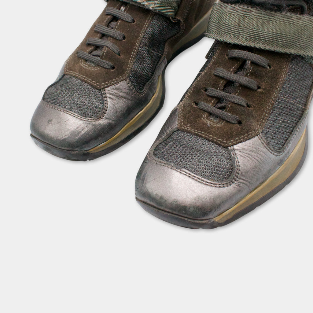 A pair of brown and black athletic shoes with a textured upper and laces.