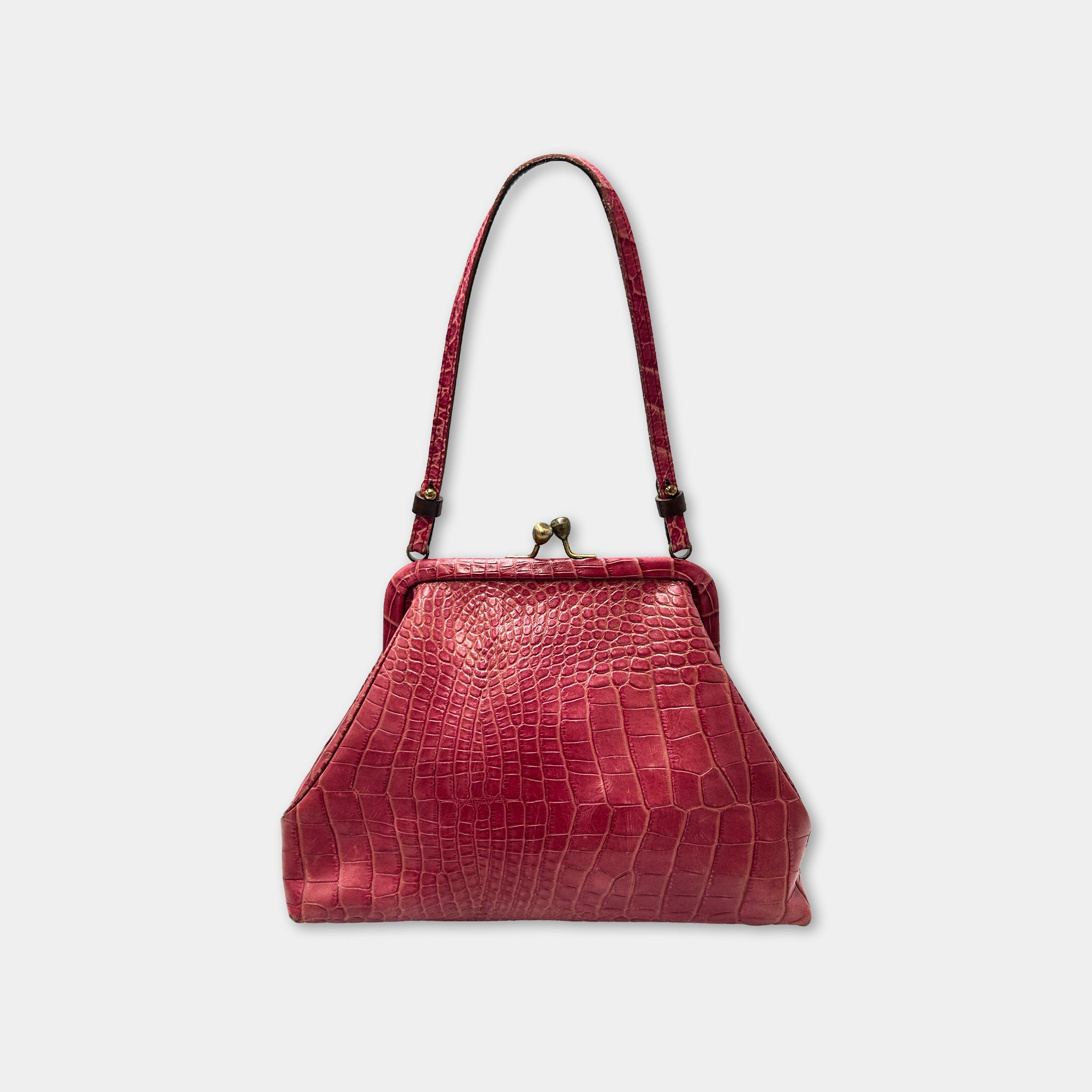A red leather handbag with a crocodile skin texture and a gold clasp.