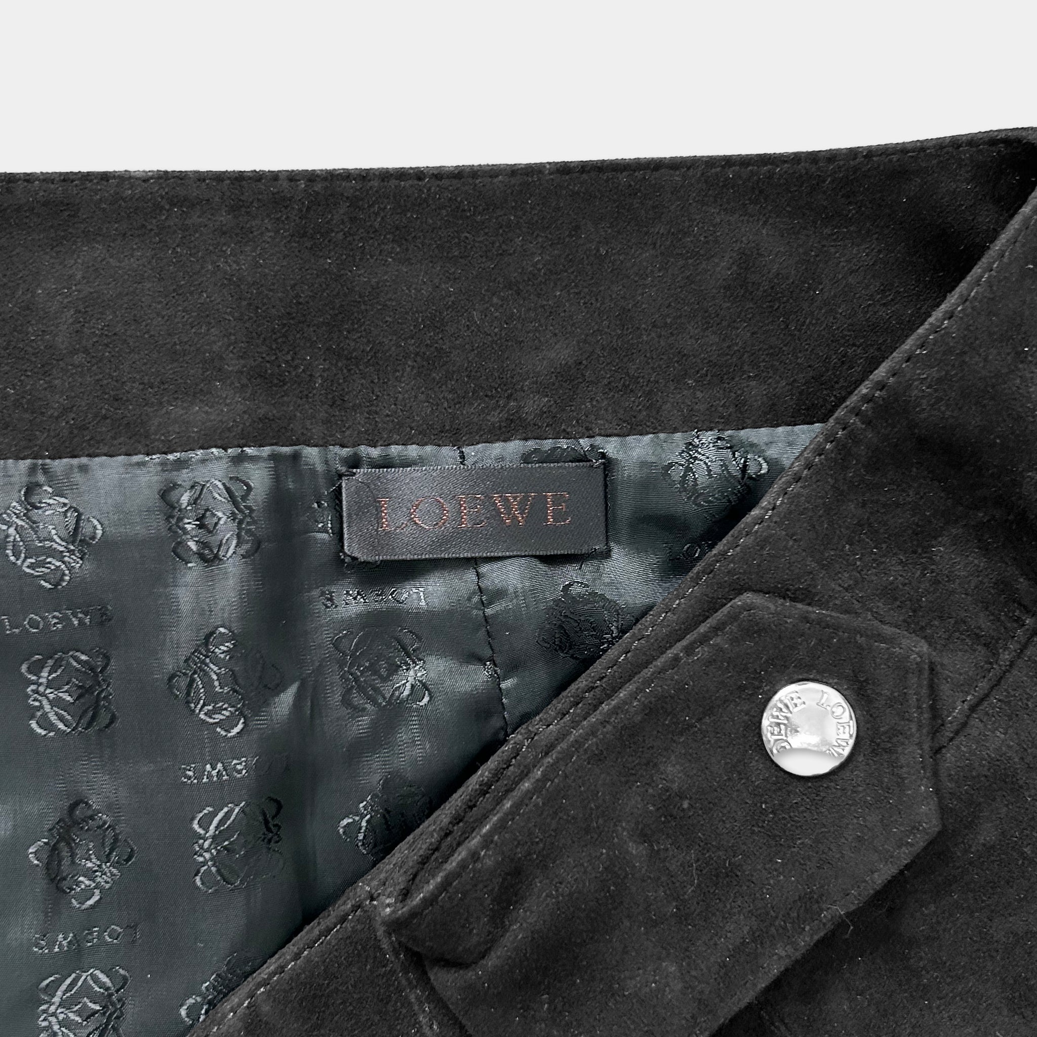 A close-up view of a black suede jacket with a LOEWE brand label visible inside the jacket.
