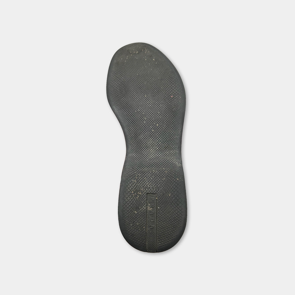 A black rubber sole of a shoe is shown against a white background.