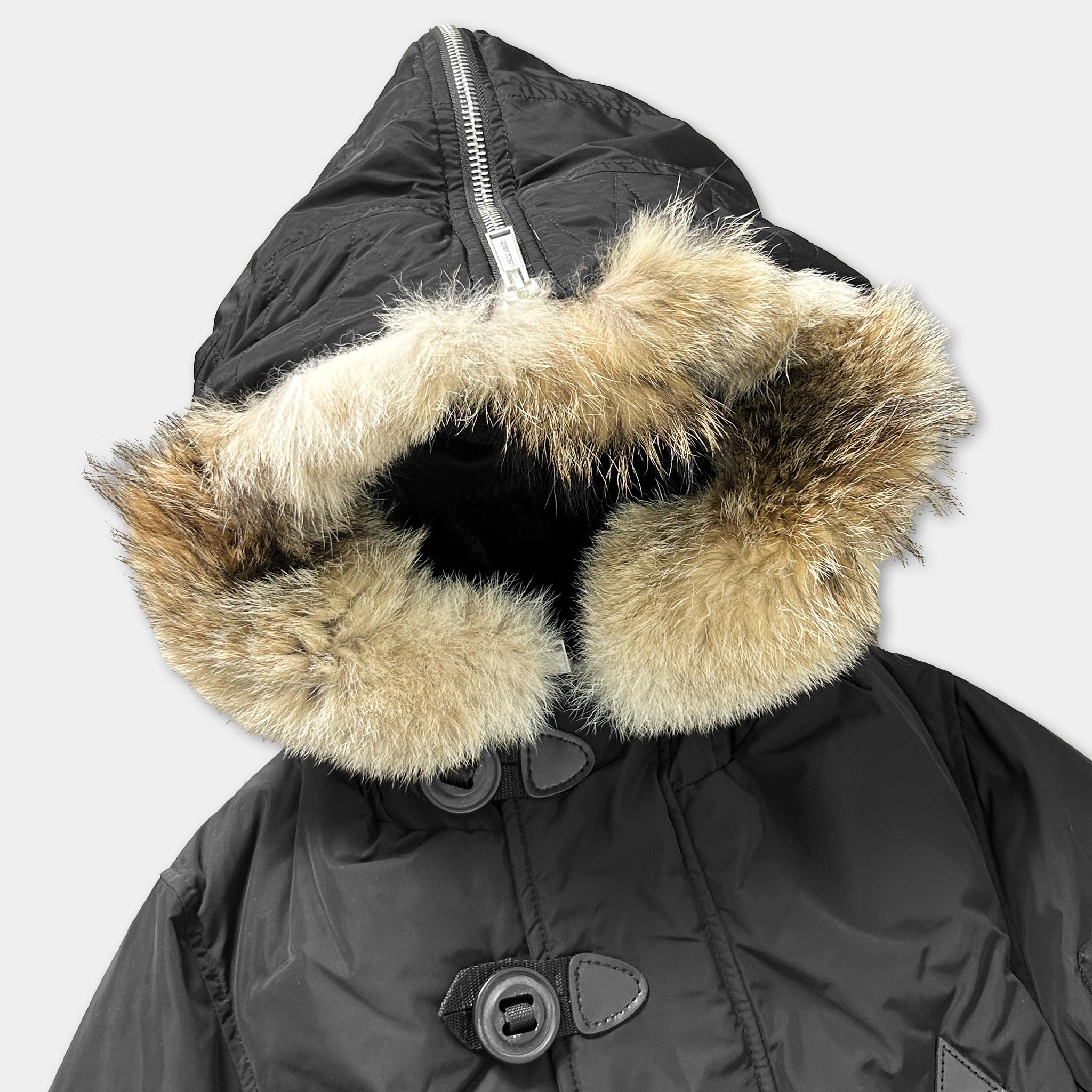 A black winter coat with a fur-lined hood and zipper.