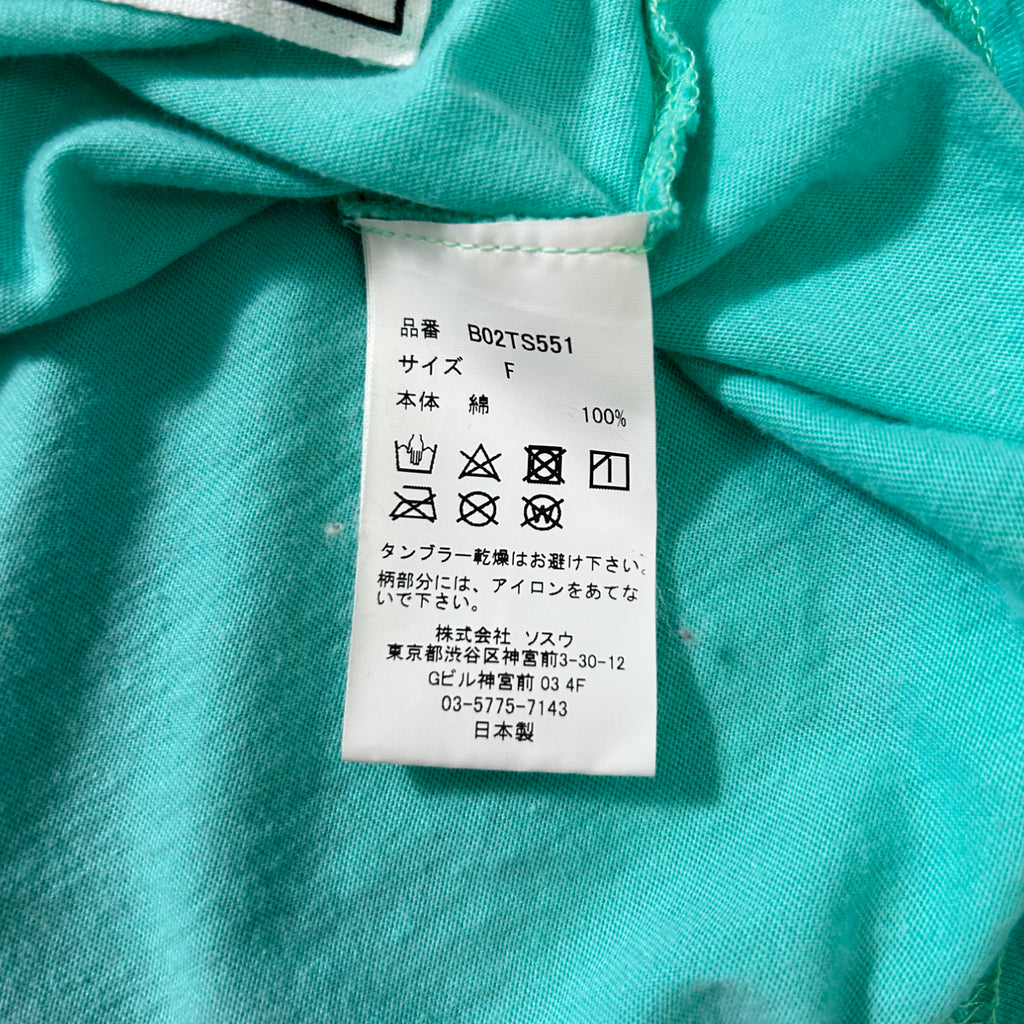 a close-up view of a white label with text and symbols on a turquoise fabric.