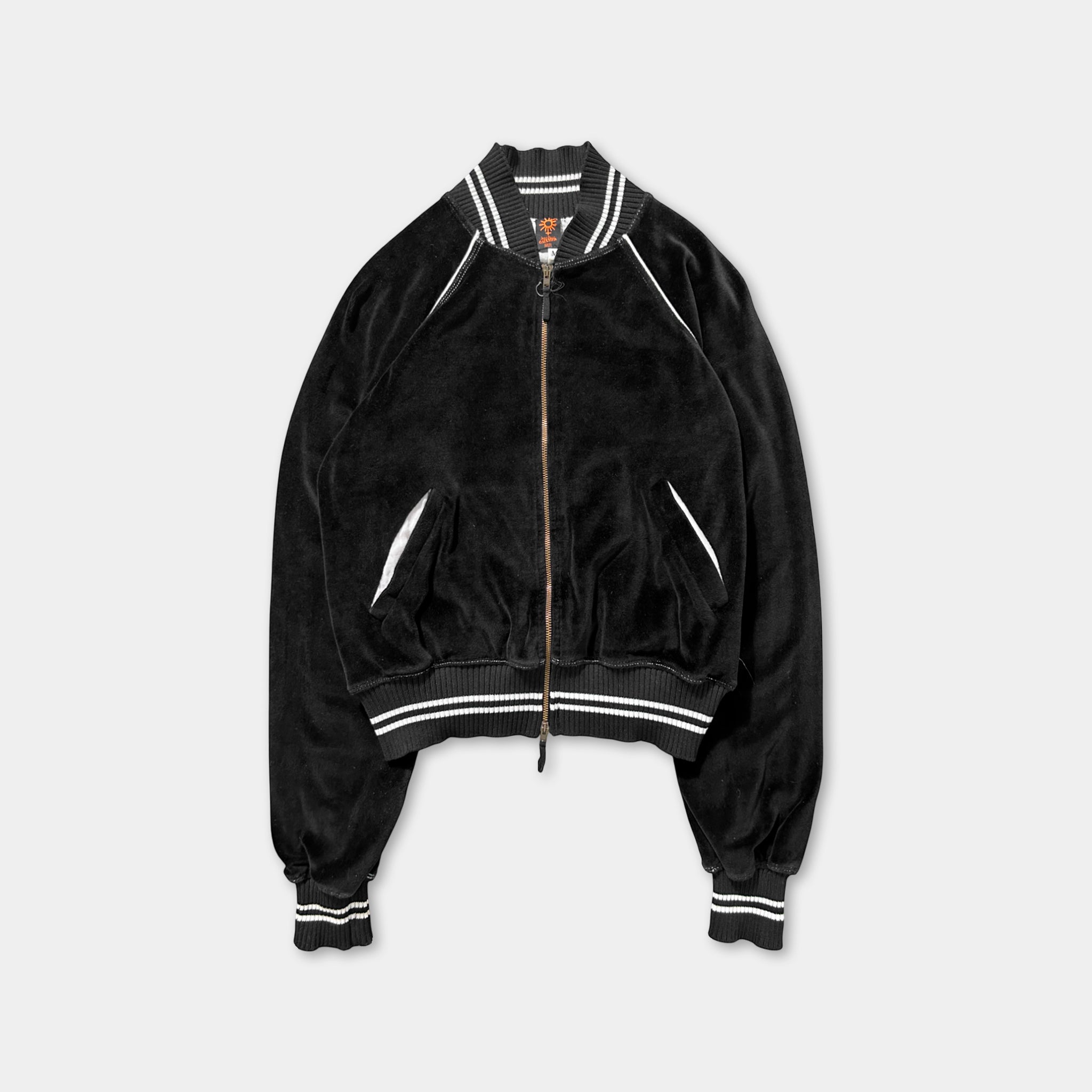 A black velvet jacket with white stripes, featuring a zipper and two pockets.
