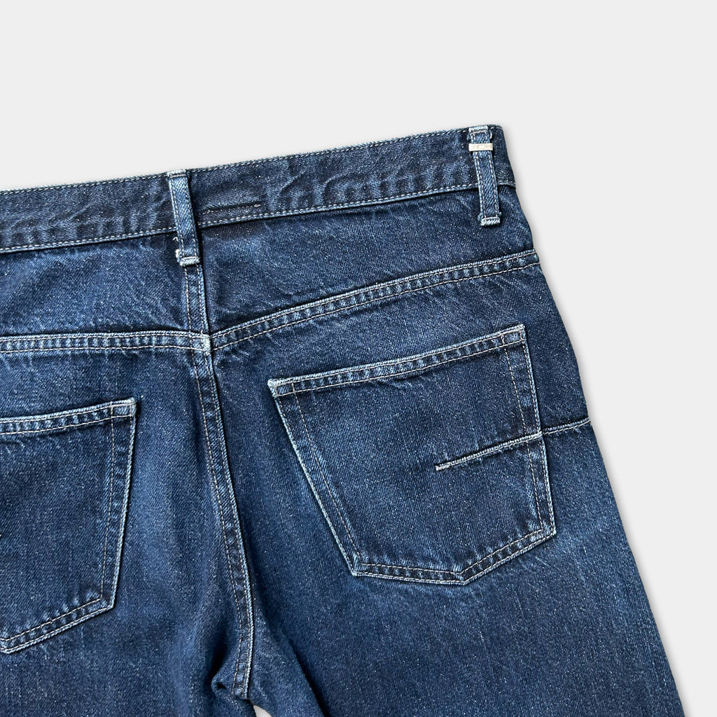 A pair of blue jeans with a pocket and zipper detail.