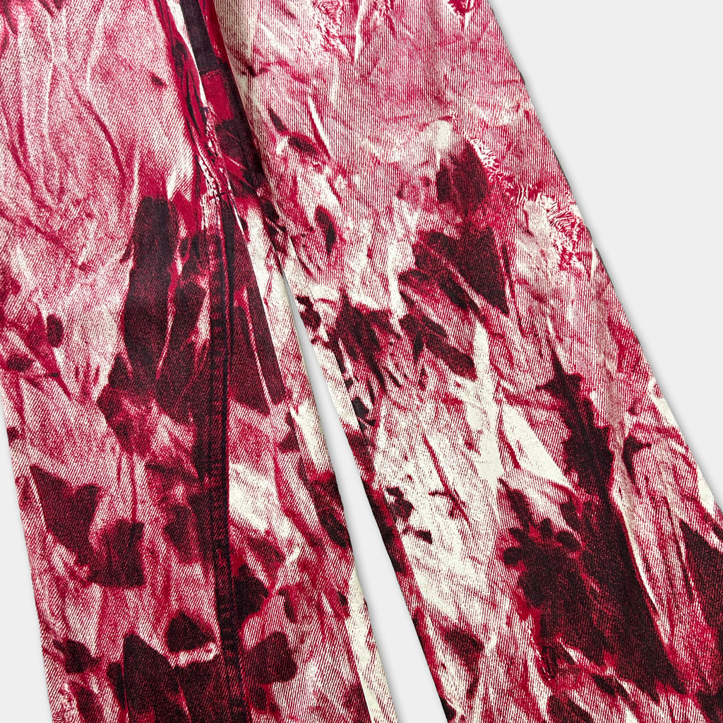 a close-up view of a pair of red and white patterned fabric, possibly jeans or pants, with a textured and abstract design.