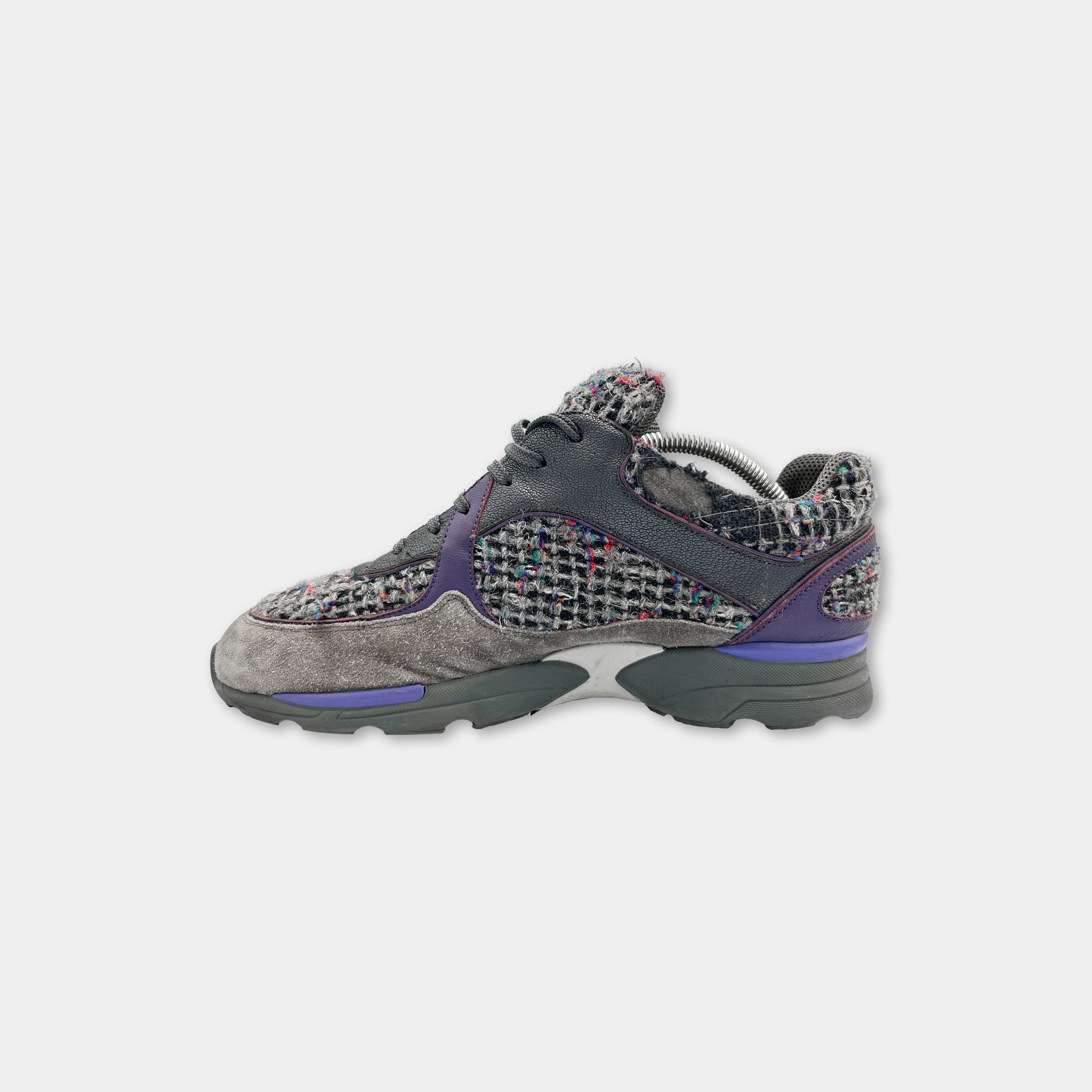 A pair of grey and purple sneakers with a checkered pattern.