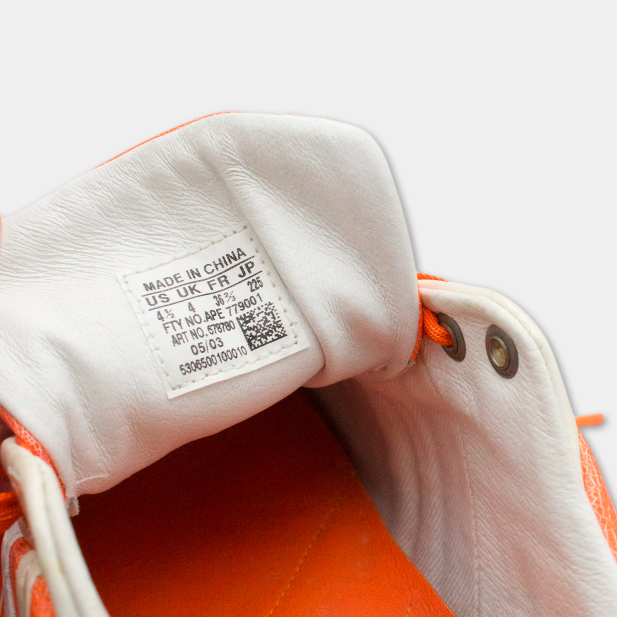 the interior of a shoe, specifically the sole and the laces, with a label indicating that the shoe is made in China.