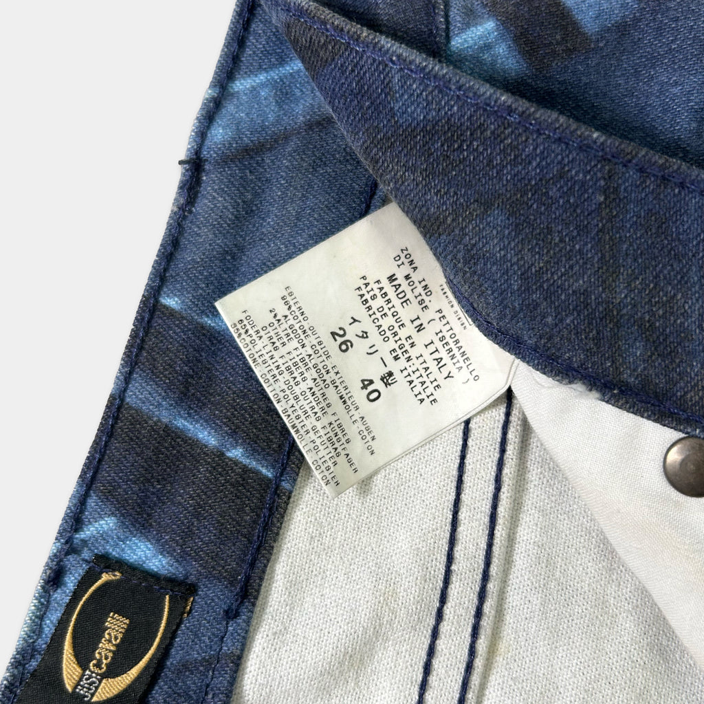 a close-up view of a pair of blue jeans, with a label attached to the waistband.