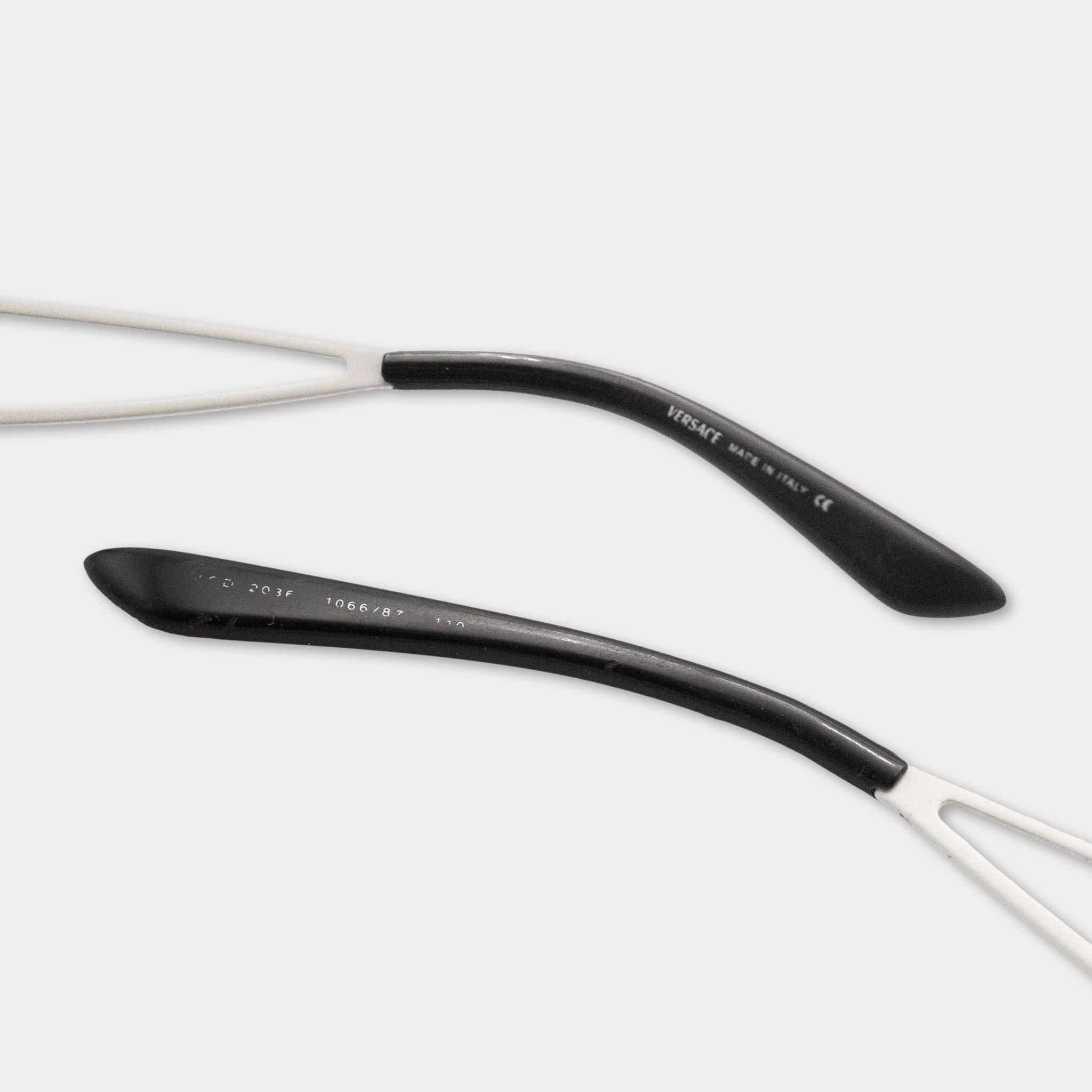 a pair of black and white eyeglasses with a curved black frame and white arms.