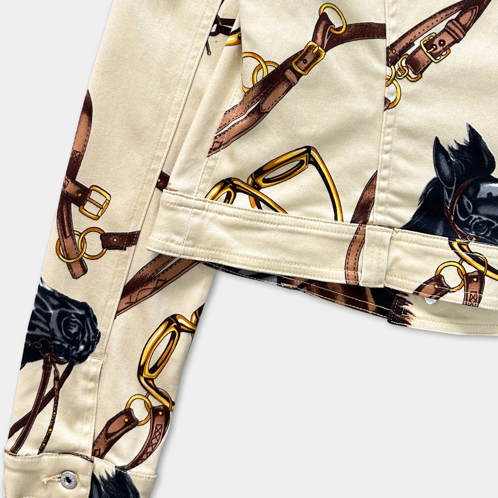 a close-up view of a beige jacket with a pattern of brown leather straps and a black horse on the front.