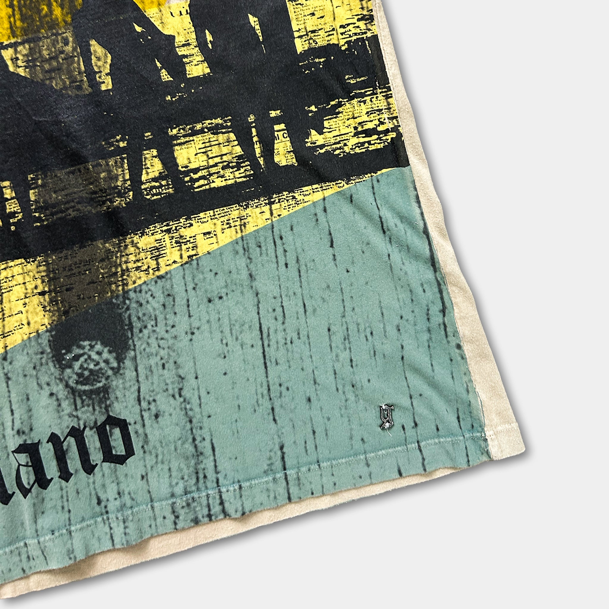 The image is a close-up of a printed fabric with a textured pattern and a small logo or symbol on the fabric.