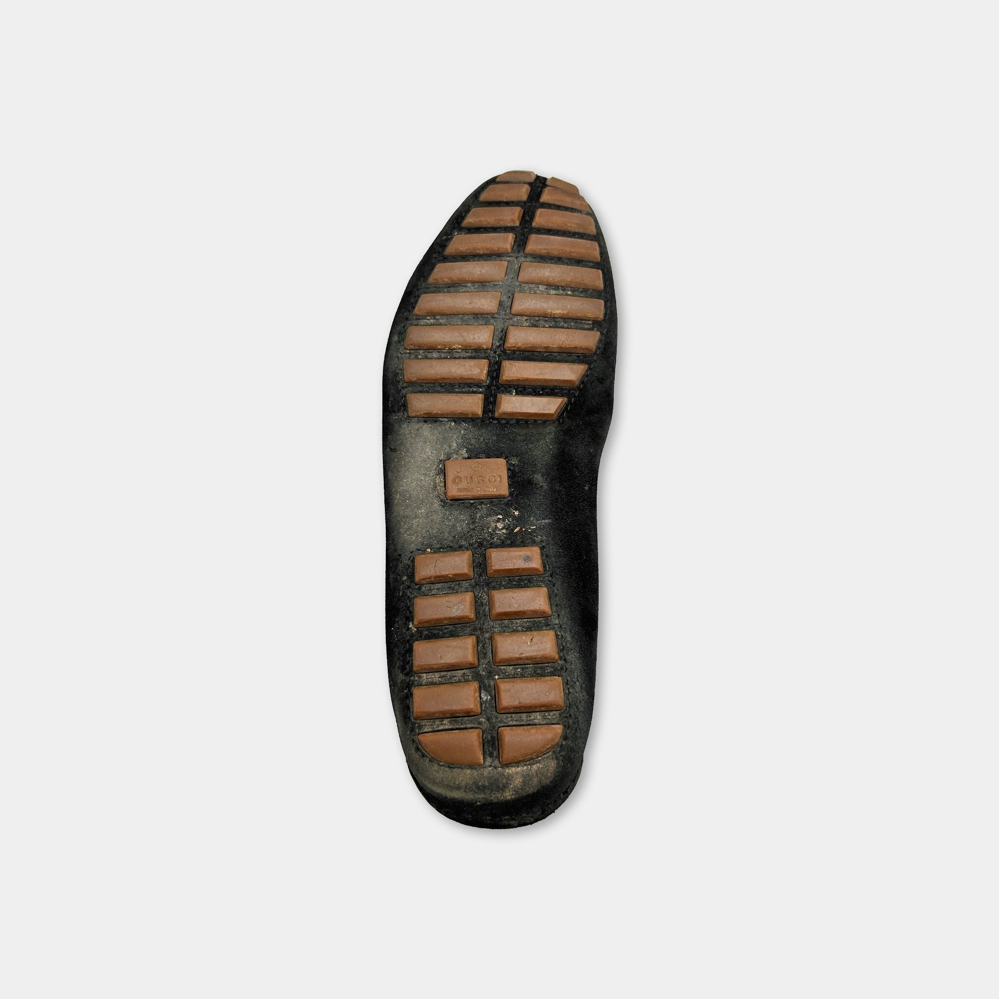 A close-up view of a black shoe sole with a distinctive tread pattern.