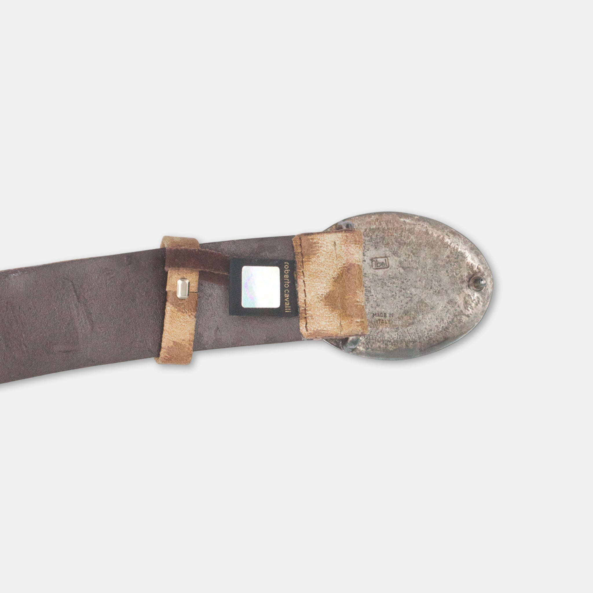 A brown leather belt with a metal buckle and a small square object attached to it.