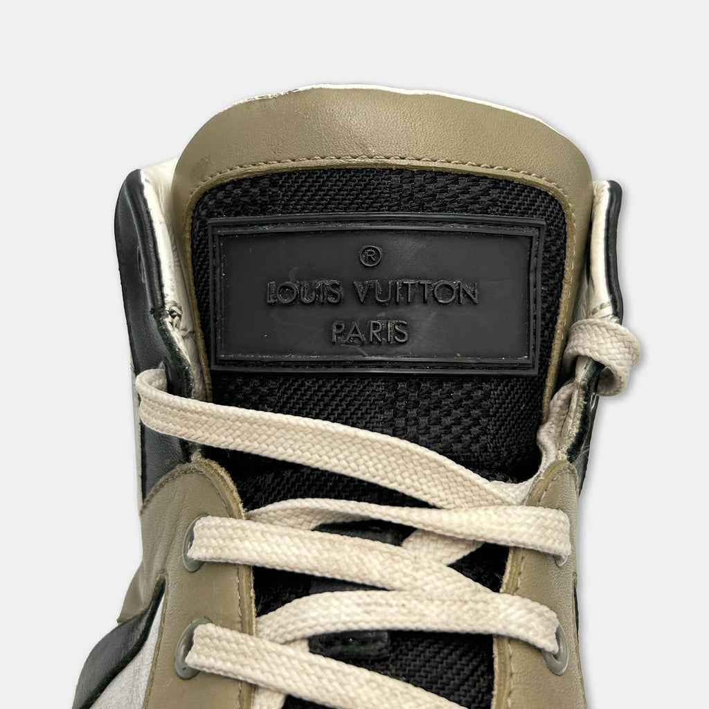 A close-up of a black and tan sneaker with a black and white logo on the side.