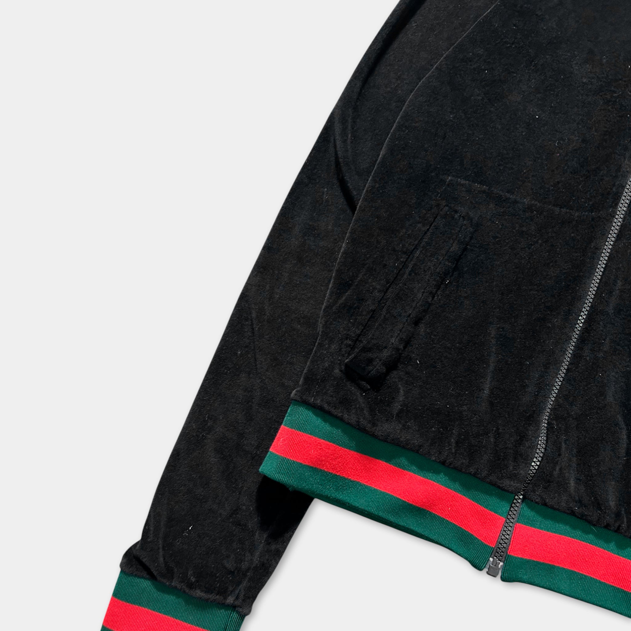 A black velvet jacket with red and green stripes on the sleeves and hem.