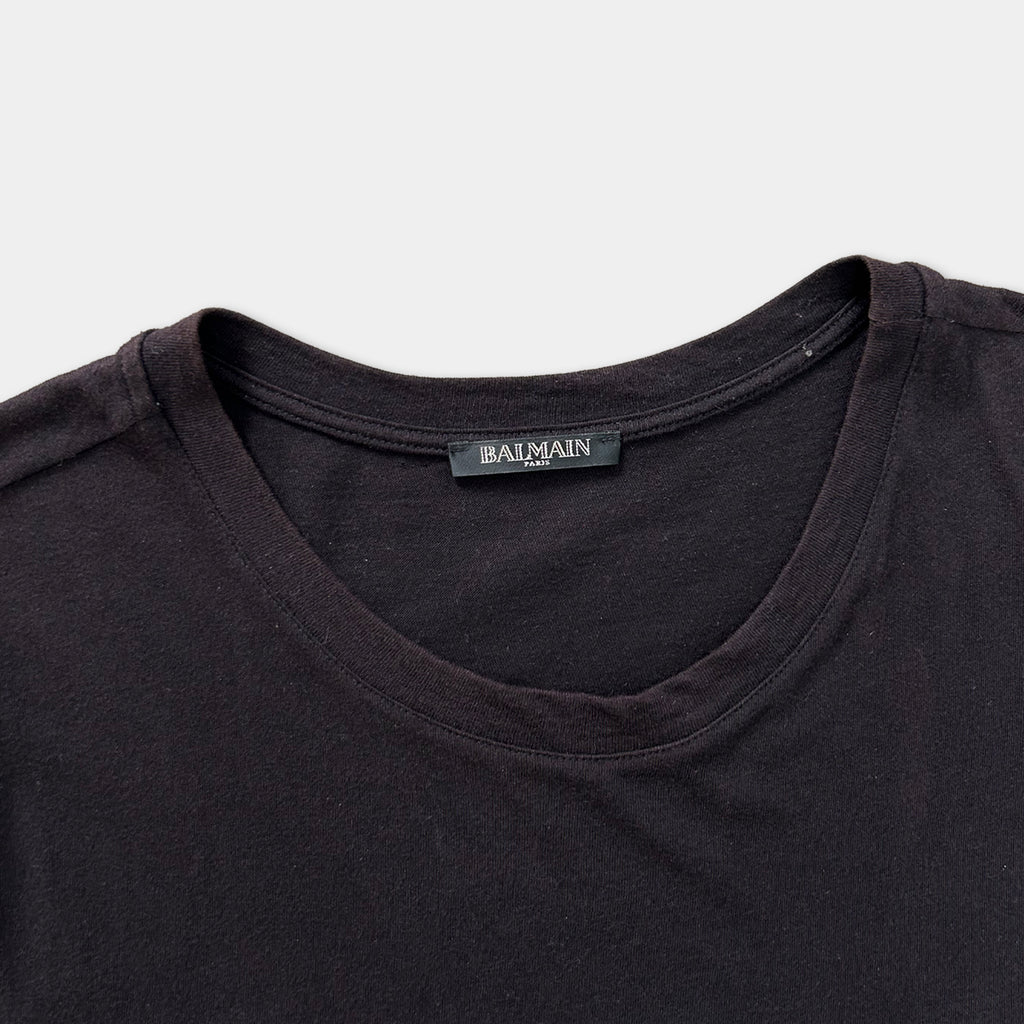 A close-up view of a dark-colored t-shirt with a label on the collar.