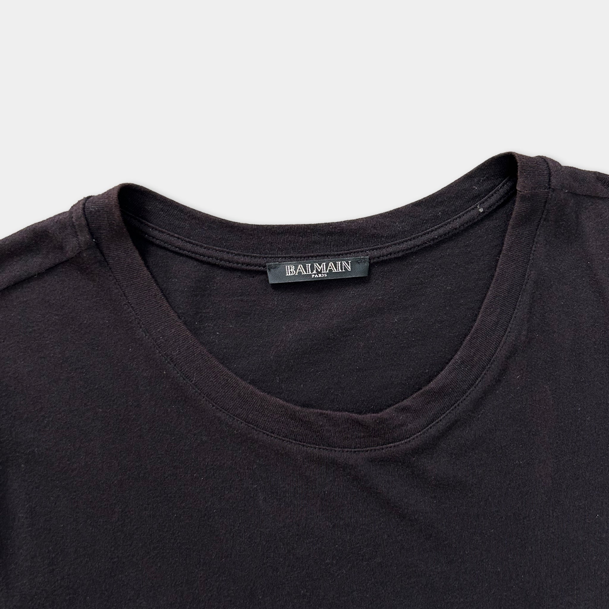 A close-up view of a dark-colored t-shirt with a label on the collar.