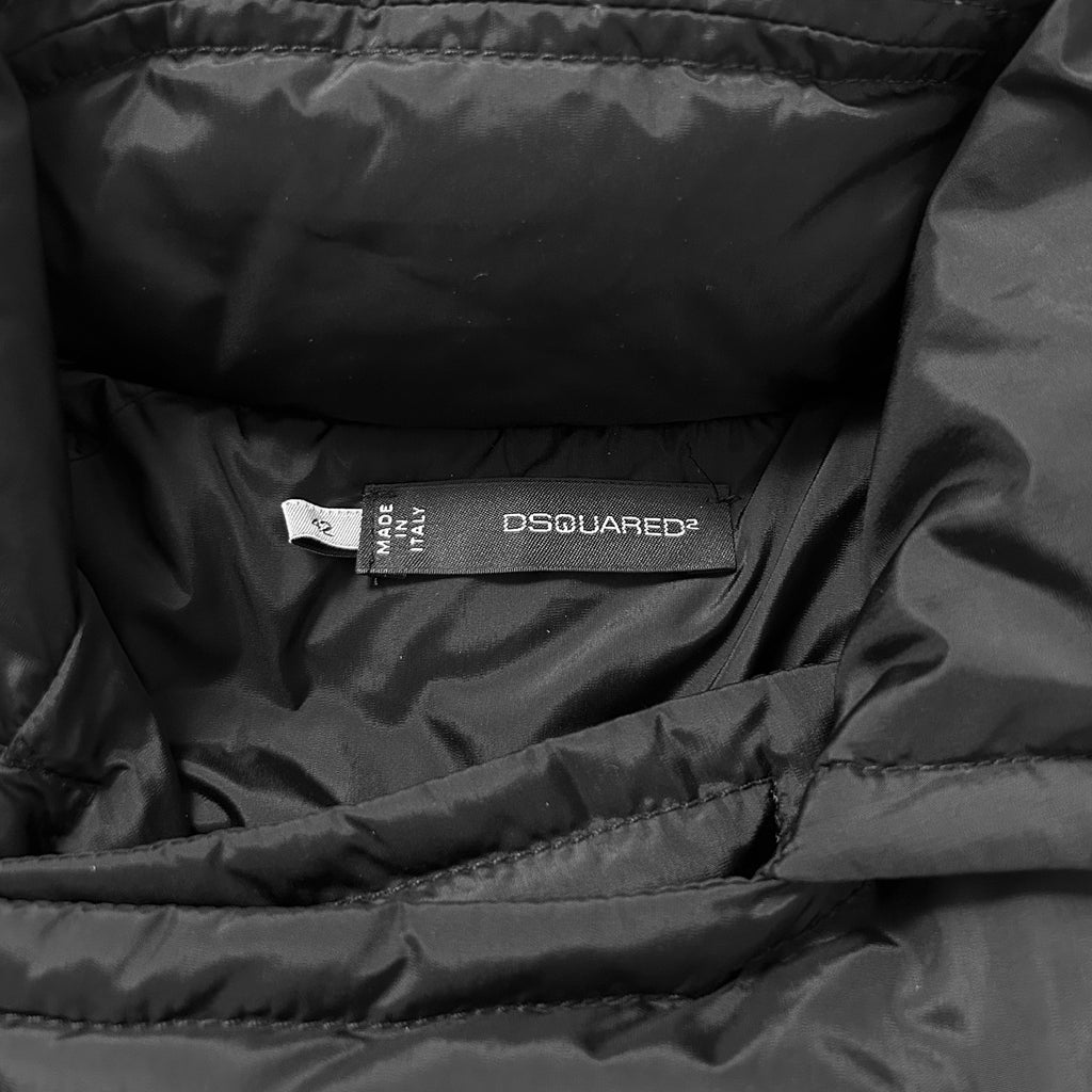 A close-up view of a black puffy jacket, showing the label "OSQUIRED" and the brand name "D'SQUARED" printed on it.