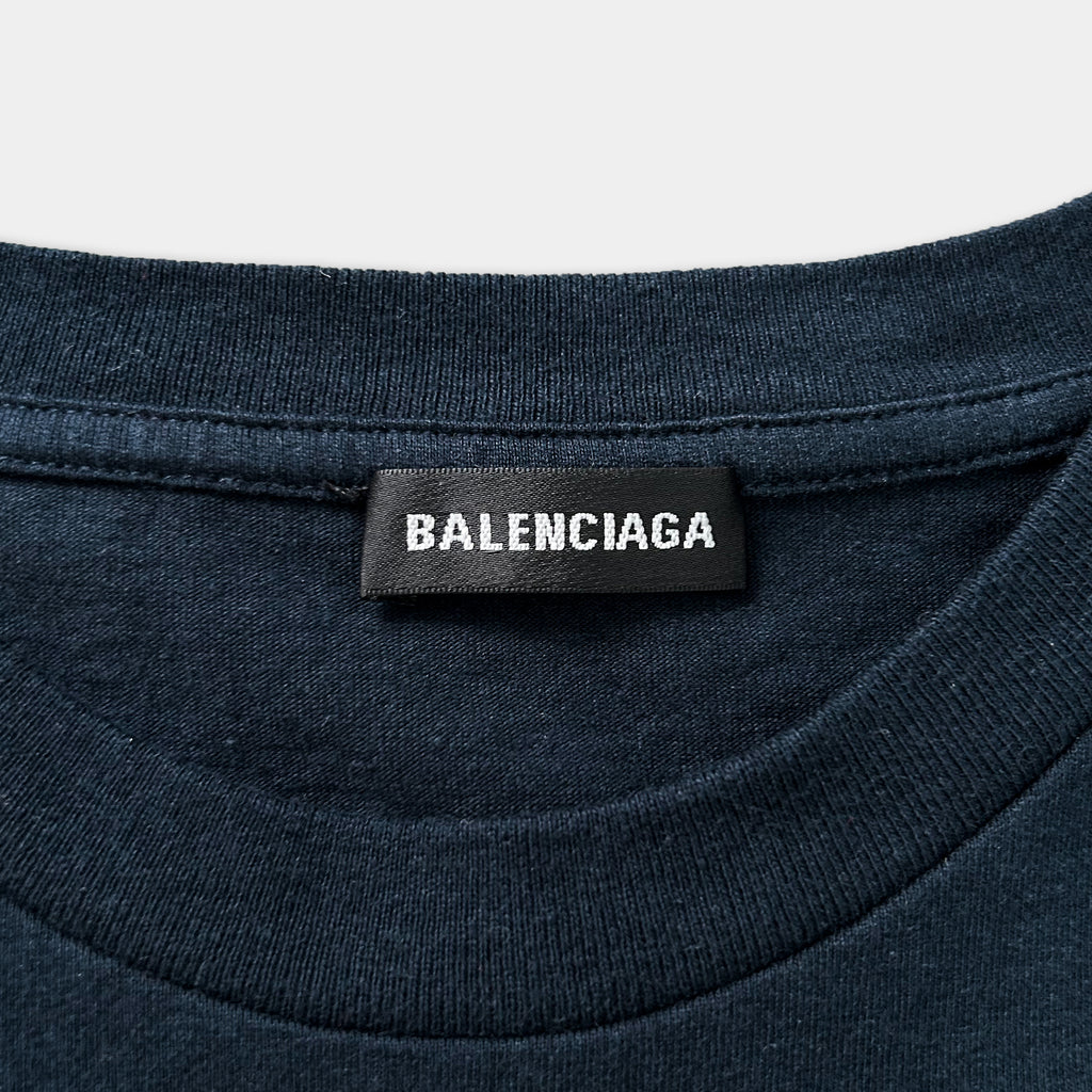 A close-up view of a dark blue t-shirt with a black label that reads "BALENCIA" prominently displayed on the shirt.
