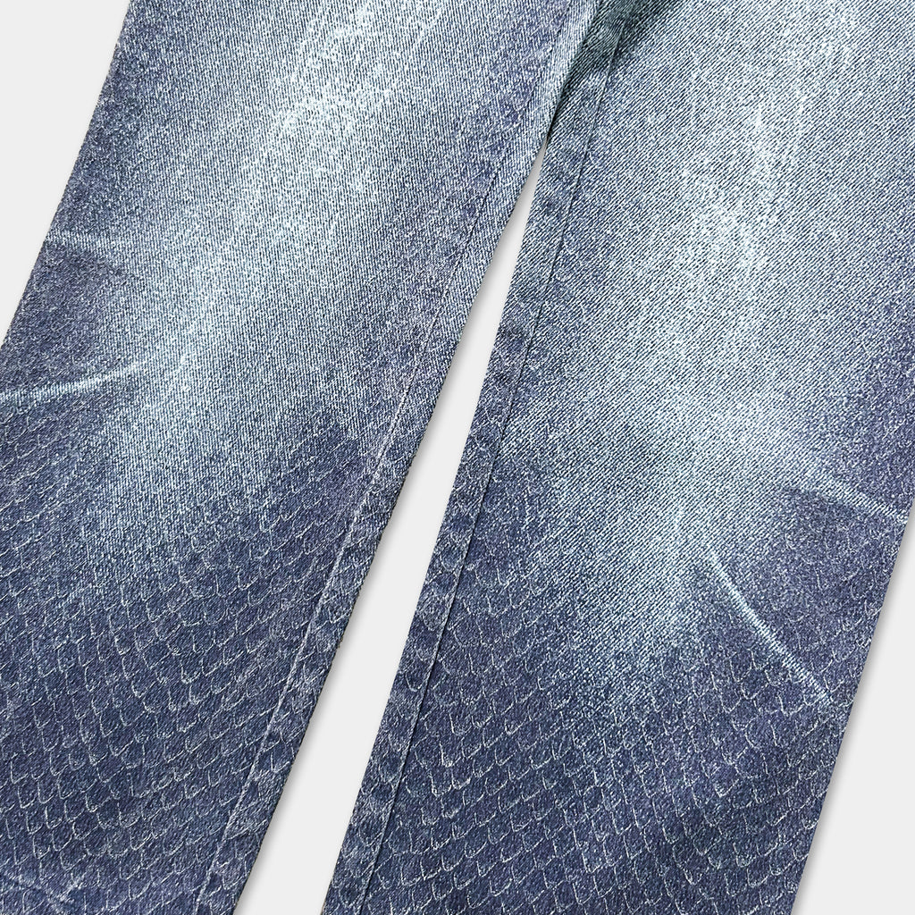A close-up view of a pair of blue jeans with a distinctive snake skin pattern.