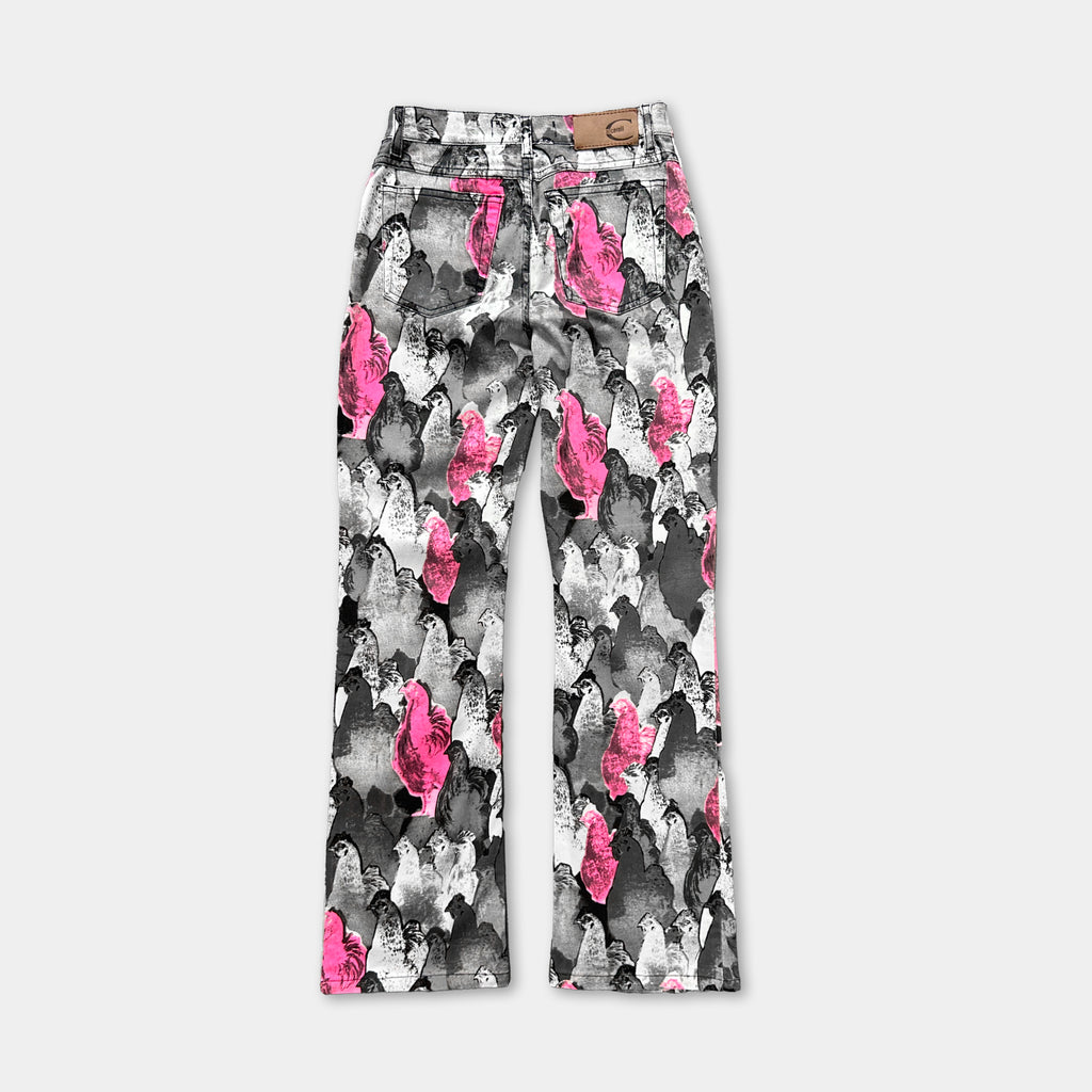 A pair of high-waisted jeans with a unique, colorful print featuring a pattern of pink and black silhouettes.
