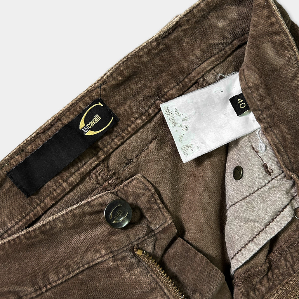 a pair of brown jeans with a black label and a zipper visible.