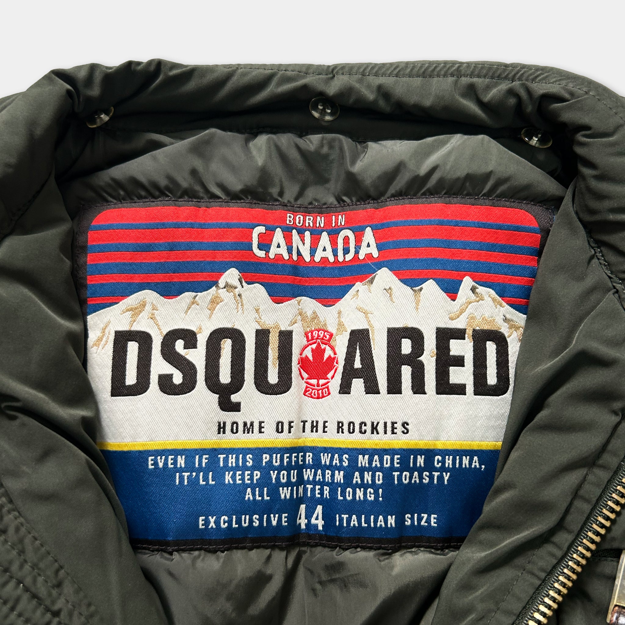 a close-up of a grey jacket with a label that features text and a mountain graphic.