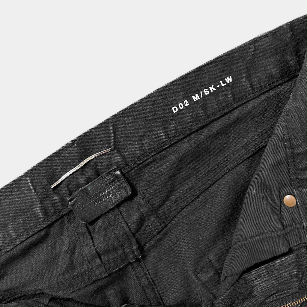 a close-up view of a pair of black jeans, with the brand name "D2 M/SK-LW" printed on the waistband.