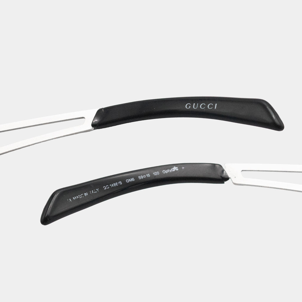 a pair of Gucci sunglasses with black handles and a white frame.